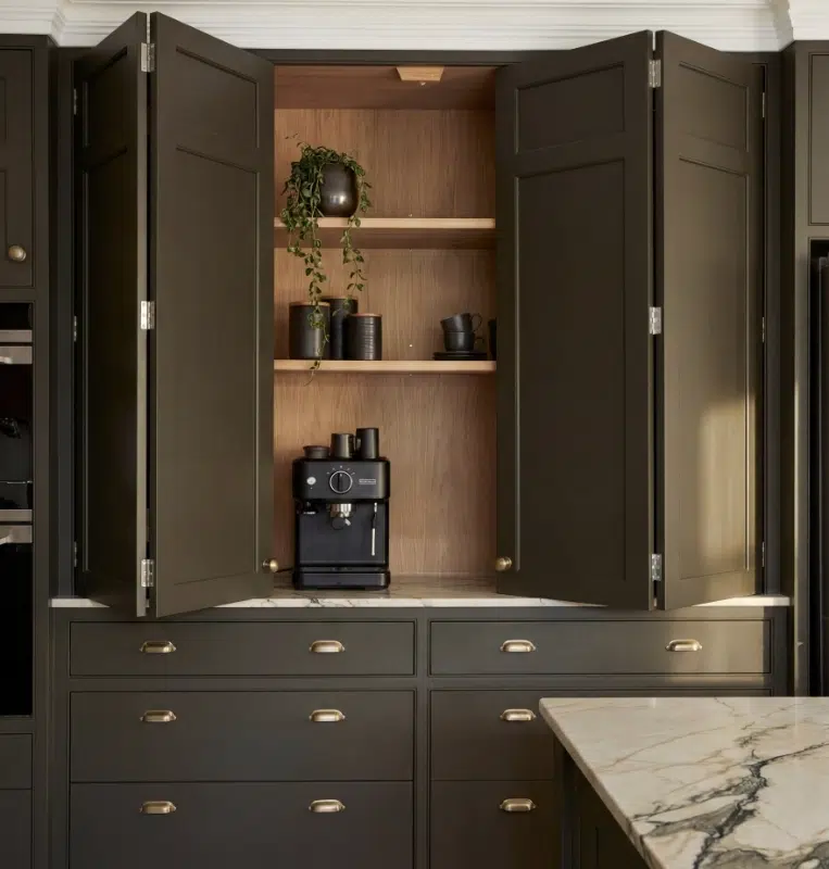 Open dark cabinet revealing a timber-lined coffee station with shelves and small-appliance storage.