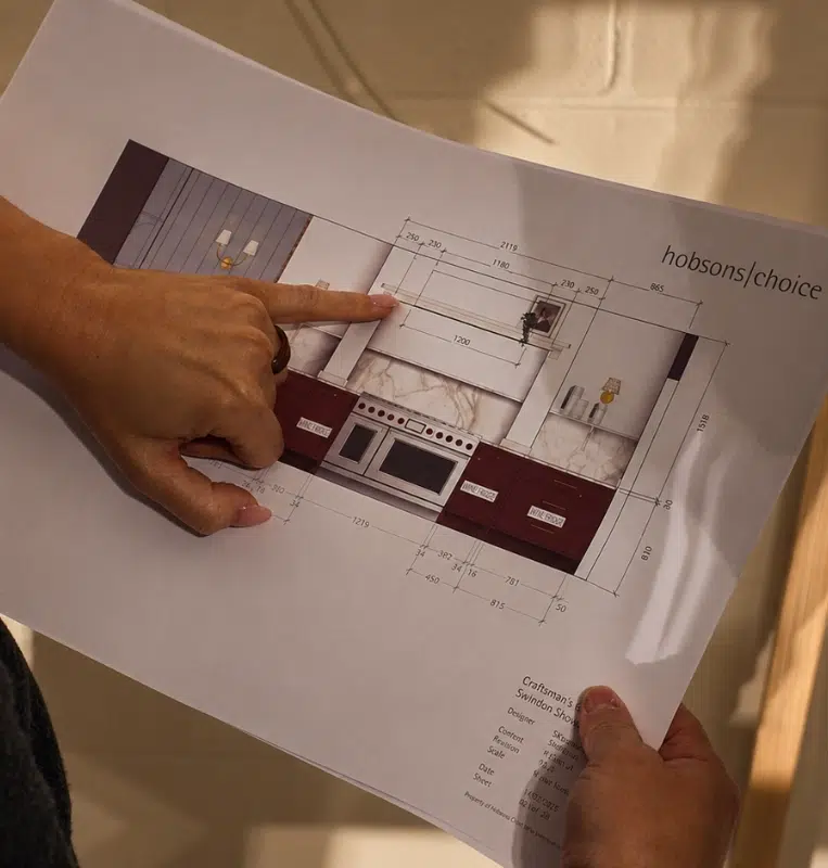 A Hobson's Choice designer explaining kitchen design plans.