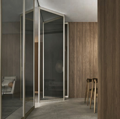 Open Rimadesio Siparium folding glass doors in a wood-panelled interior, showing the slim aluminium frame and top rail.