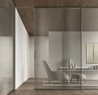 Rimadesio Velaria glass sliding doors positioned in front of a fitted dressing room and wardrobe.