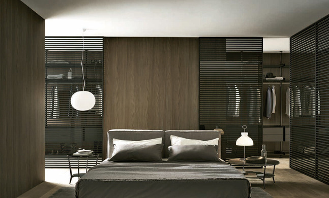 Rimadesio Stripe sliding doors framing a contemporary bedroom and dressing area with dark timber finishes