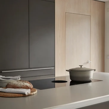 Anthracite kitchen cabinets with integrated induction hob and minimalist worktop