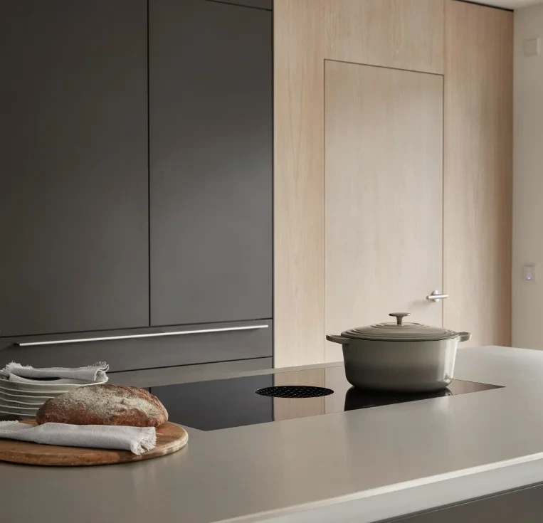 Anthracite kitchen cabinets with integrated induction hob and minimalist worktop