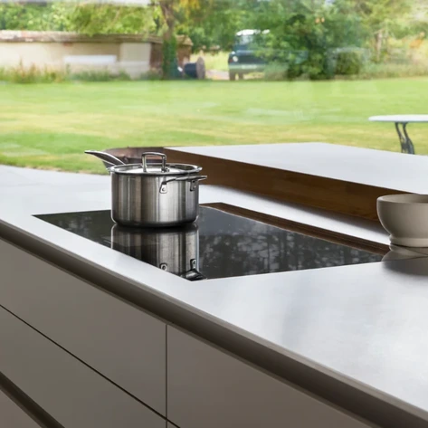View across a kitchen island into adjoining dining and living areas, showing the connection between spaces.