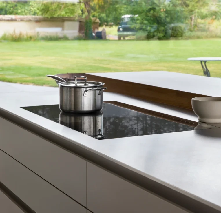View across a kitchen island into adjoining dining and living areas, showing the connection between spaces.