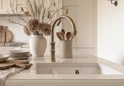 Quooker Fusion tap in patinated brass beside white undermounted sink