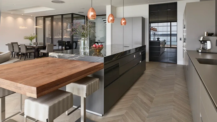 Dark kitchen island with sociable bar seating and pendant lights