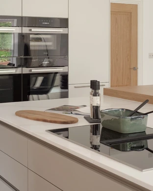 Steam drawn into a downdraft extractor integrated between the induction cooking zones.