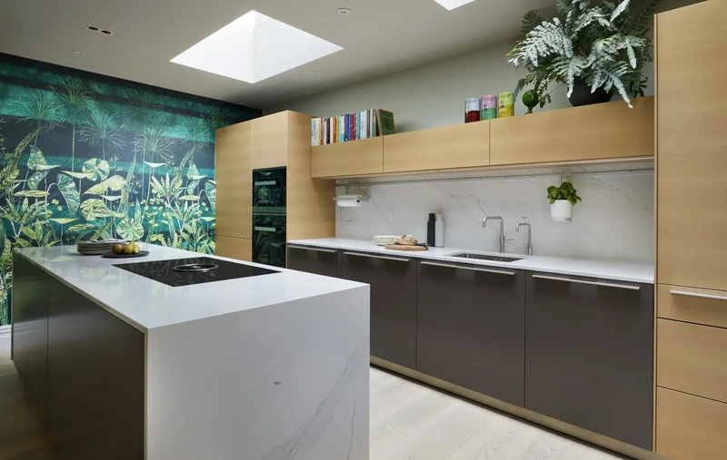 Earthy kitchen with oak cabinetry, dark finishes and lush greenery