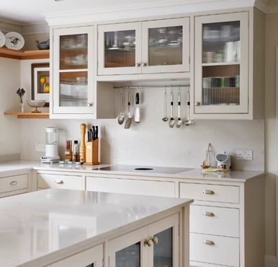 White painted kitchen cabinetry with glazed doors and traditional handles