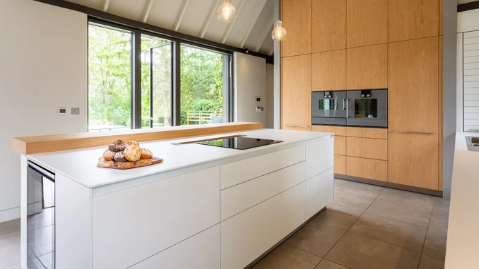 Light and airy family kitchen with white cabinetry and garden doors