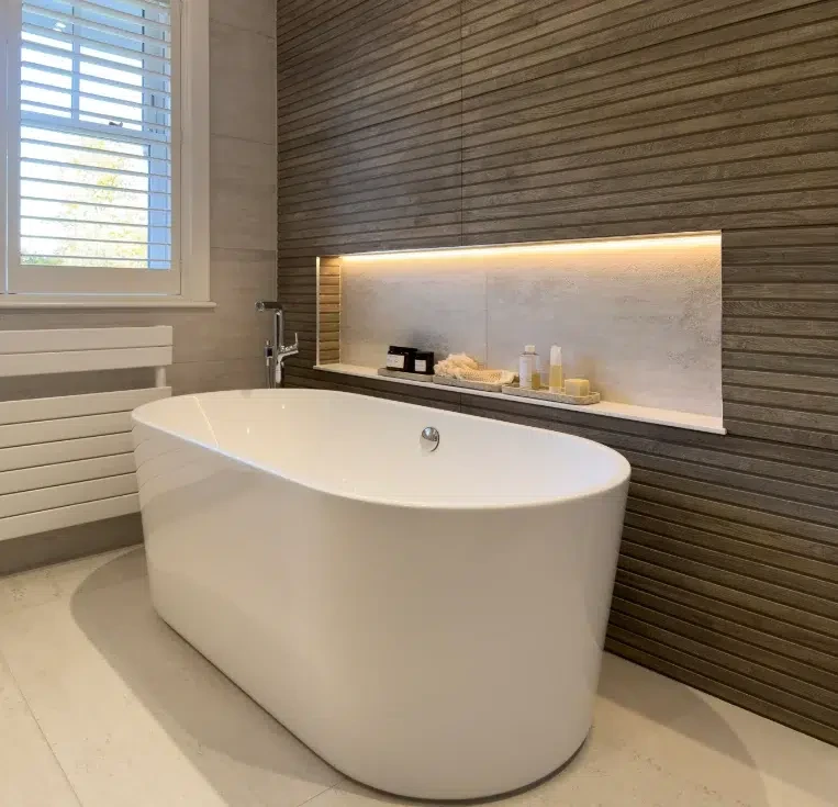 Recessed illuminated shelf above freestanding bath