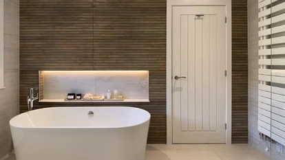 Minimalist master ensuite combining freestanding bath, vanity and shower