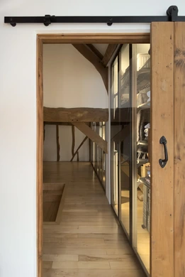 Bespoke wardrobe visible through original timber doorway in barn conversion