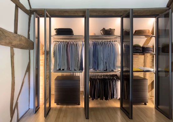 Glass-fronted wardrobe fitted beneath exposed roof beams