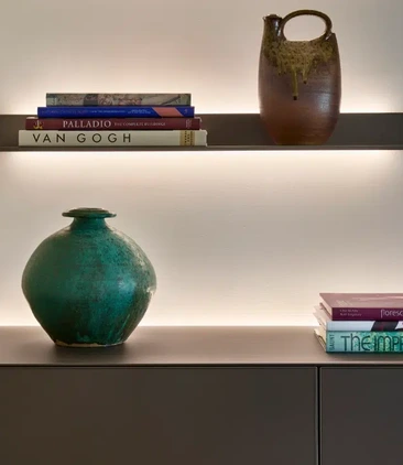 Contemporary floating shelves with books, ceramics and integrated lighting