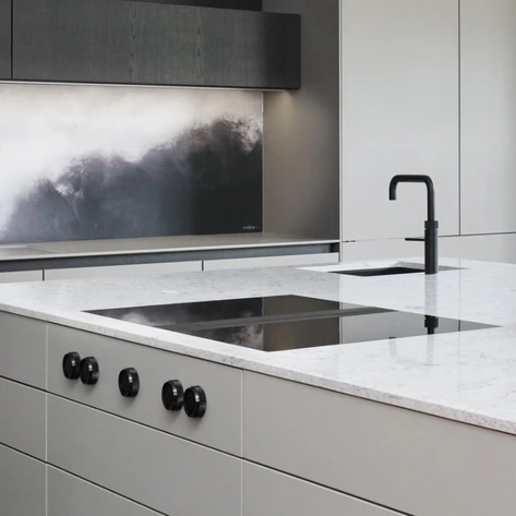 Close-up of an induction hob with integrated extraction set into a light worktop.
