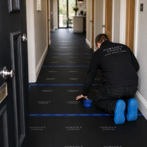 Hobson's Choice installer protecting a property hallway with flooring material