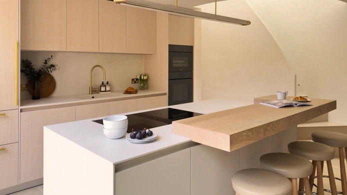 Contemporary white oak kitchen with island, integrated ovens and pendant lighting