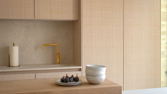 Gold-finished undermount sink and matching pull-down tap set into the pale quartz worktop