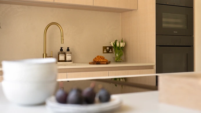 Close-up of textured white oak drawer fronts beneath the pale quartz worktop
