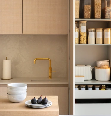 bulthaup b3 kitchen Open oak storage cabinet with pocket doors, internal shelves and drawers beside white cabinetry.
