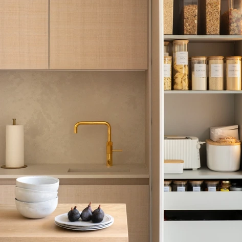 bulthaup b3 kitchen Open oak storage cabinet with pocket doors, internal shelves and drawers beside white cabinetry.