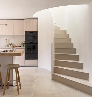 bulthaup b3 island with black BORA hob, white oak breakfast bar and curved staircase