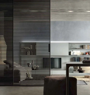 Black Rimadesio Stripe sliding doors with horizontal aluminium cross-members screening an open-plan living area