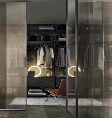 Rimadesio Velaria glass sliding doors positioned in front of a fitted dressing room and wardrobe.