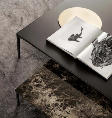Detail of a dark Rimadesio coffee table surface with books and decorative objects