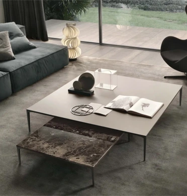 Group of low Rimadesio Tray tables in contrasting stone and pale finishes beside a grey sofa