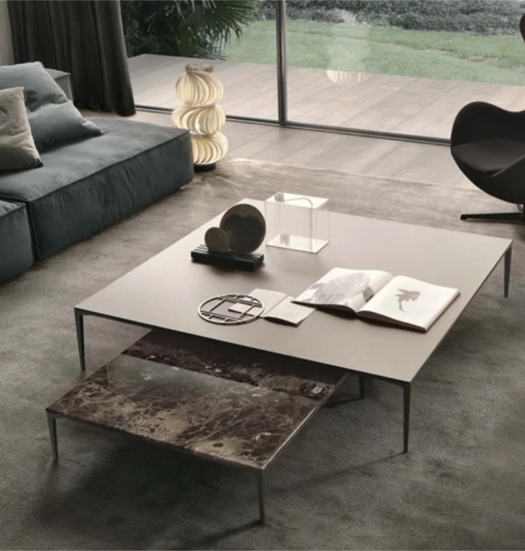 Group of low Rimadesio Tray tables in contrasting stone and pale finishes beside a grey sofa