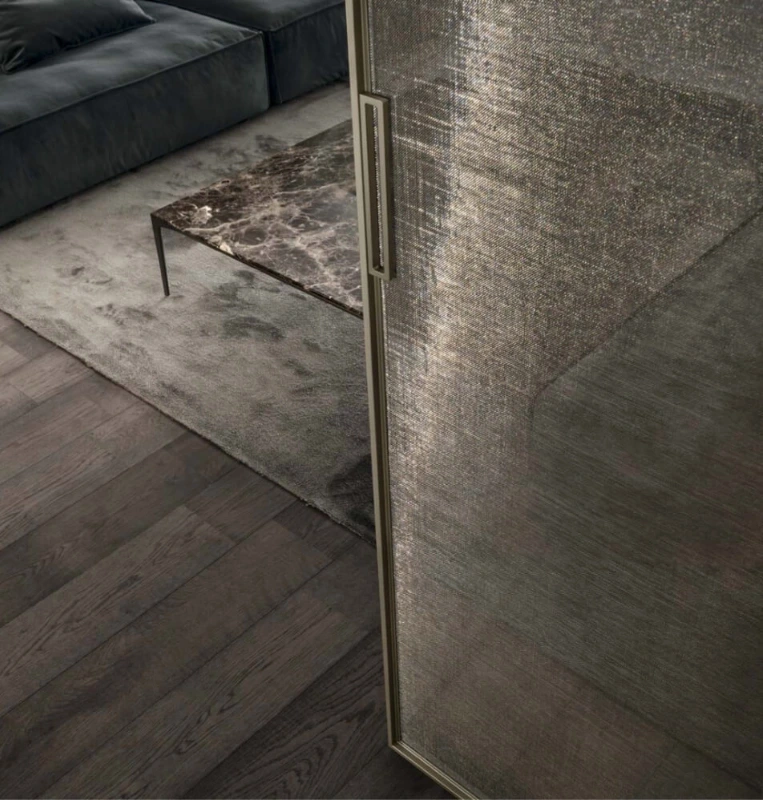 Close-up of a Rimadesio Velaria sliding door with textured glass, slim aluminium frame and vertical handle.