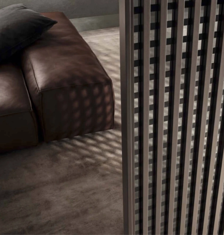Rimadesio Daimon grid-pattern sliding door casting a patterned shadow across a leather sofa