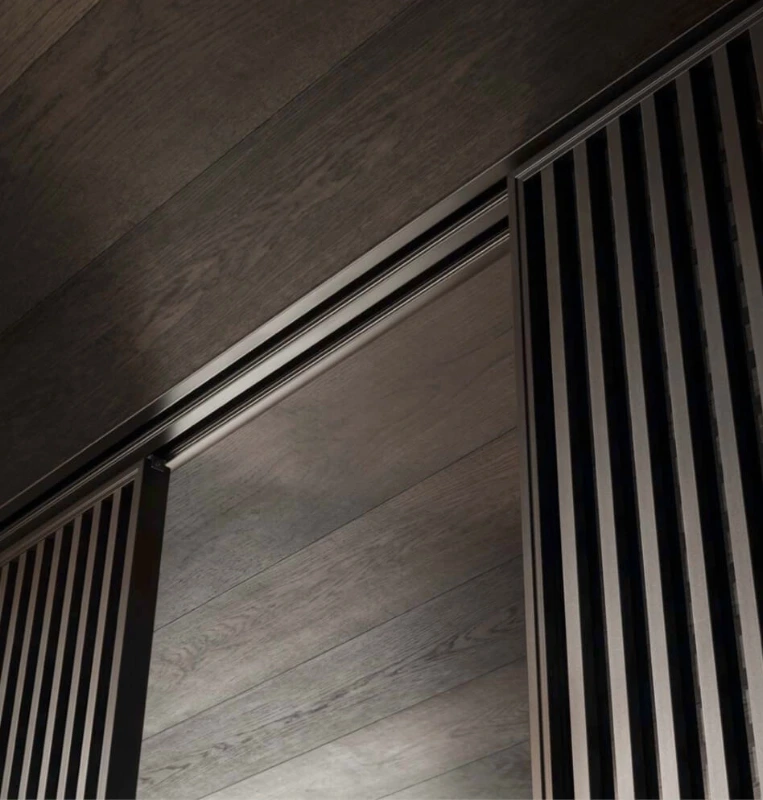 Detail of Rimadesio Daimon sliding panels suspended from the recessed multi-track ceiling rail