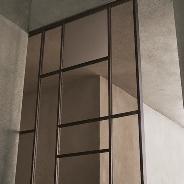 Close-up of the upper Rimadesio Maxi sliding door frame showing the irregular grid and glass panel divisions.
