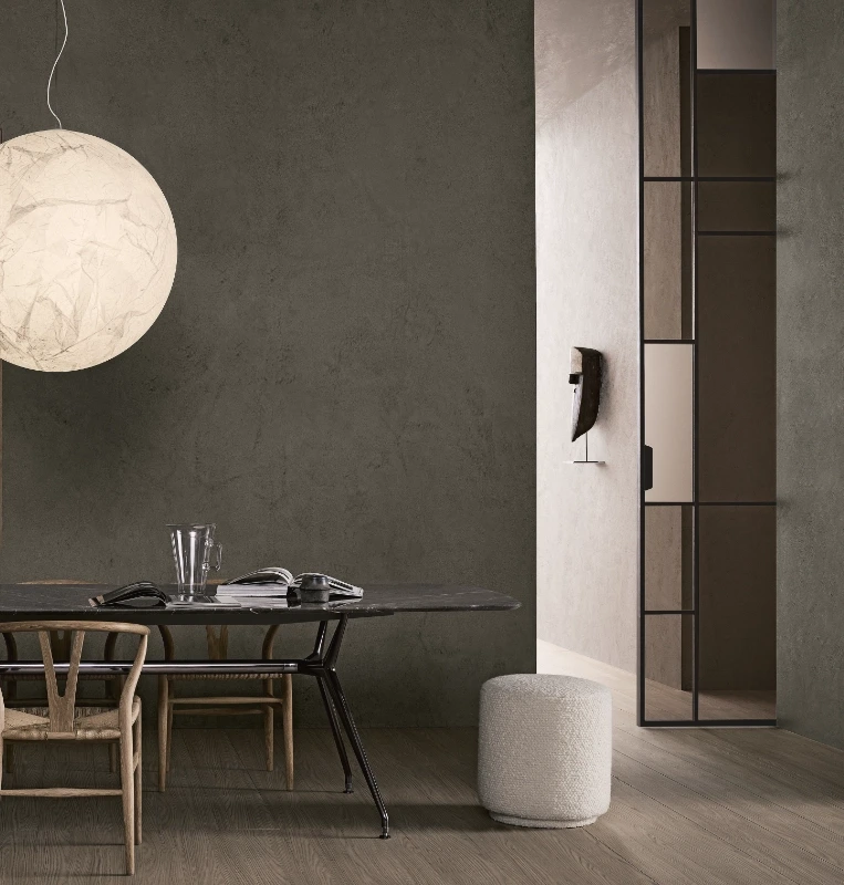 Rimadesio Maxi sliding door partly open beside a dining area, retaining a view into the adjoining room.