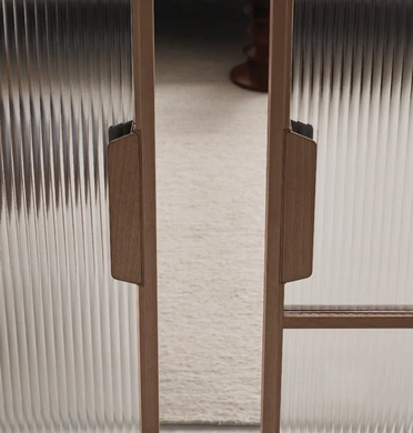 Rimadesio Maxi sliding door partly open between two rooms, showing its tall irregular grid frame and glass panels.