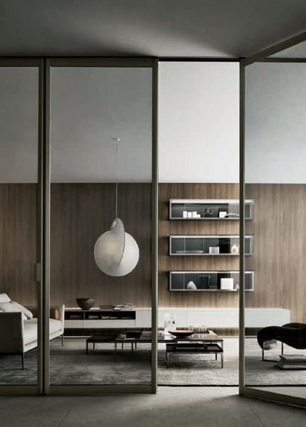 Black-framed Rimadesio Siparium glass doors dividing a contemporary living and dining space.