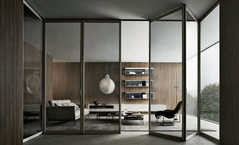 Black-framed Rimadesio Siparium glass doors dividing a contemporary living and dining space.
