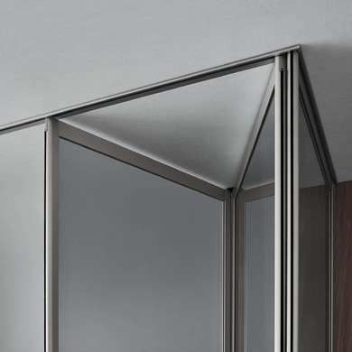 Close-up of the upper corner of a Rimadesio Siparium door, showing the aluminium frame and ceiling rail.