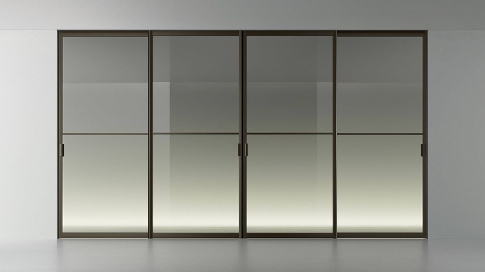 Wide view of a Rimadesio Siparium glass door system dividing a contemporary interior.