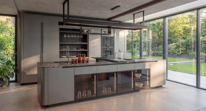 Contemporary Arrital kitchen with a pale island, glazed storage and full-height doors opening to the garden.