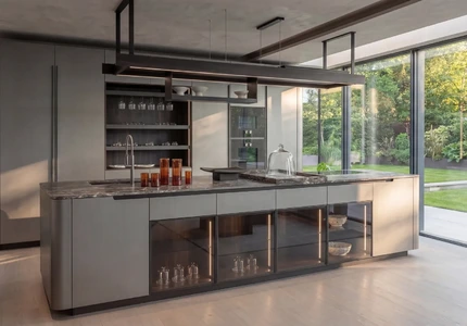 Contemporary Arrital kitchen with a pale island, glazed storage and full-height doors opening to the garden.