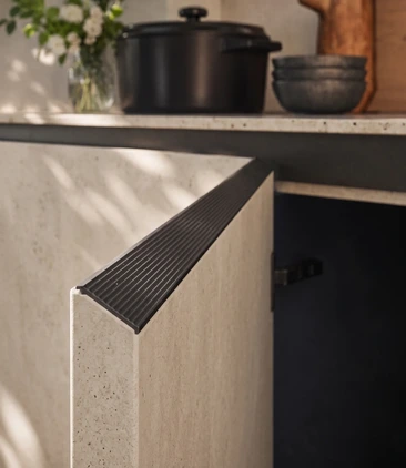 Close-up of a light textured Arrital cabinet front with an integrated dark ribbed handle.