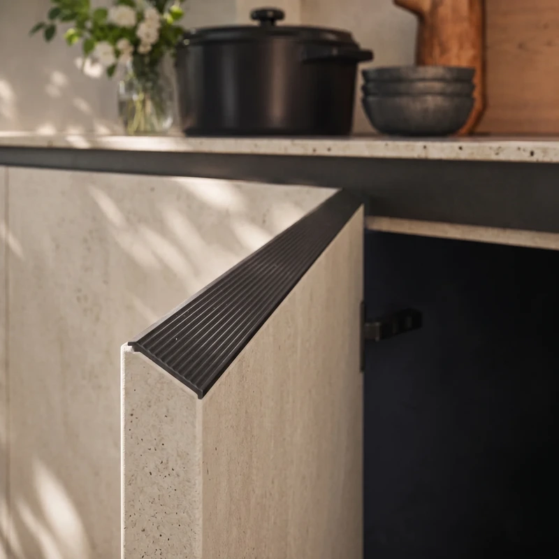 Close-up of a light textured Arrital cabinet front with an integrated dark ribbed handle.
