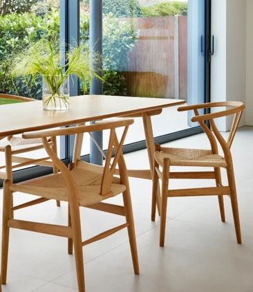 Carl Hansen & Son timber dining table with woven-seat wooden chairs