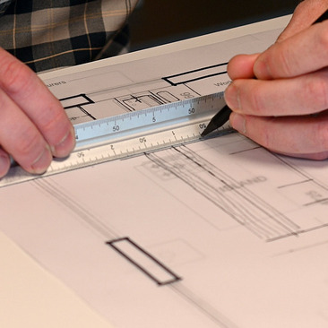 Hobson’s Choice kitchen designer reviewing plans with clients in the Swindon showroom.