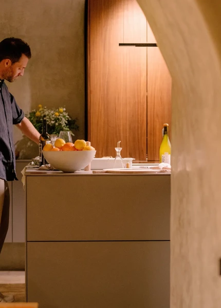A man cooking on the end of a bulthaup kitchen island in a Mediterranean-style property